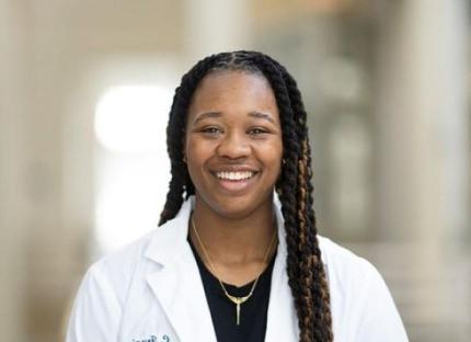A smiling Professor Chantrell Frazier in her lab coat